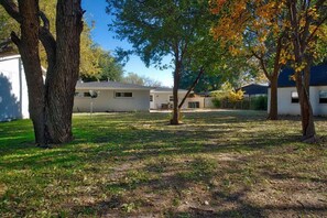 A residential area with a house, trees, and a clear sky. - Spacious Luxurious House, Big Groups and Pool (Irving)
