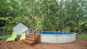 A wooden deck with a built-in swimming pool, a small shed, and two yellow lounge chairs. - Spacious Luxurious House, Big Groups and Pool (Irving)