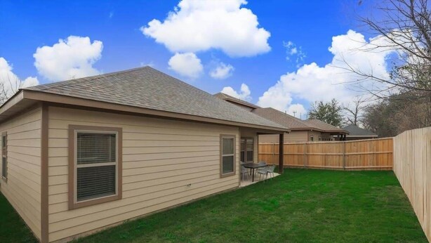 A single-story house with a fenced backyard, a covered patio, and a visible garage. - Your Vibrant Dallas Getaway Home (Dallas)