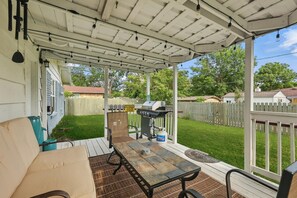 A covered patio with a grill, outdoor seating, and a view of the backyard. - Charming 3-bed/2-bath Hidden Gem w Yard (Richardson)