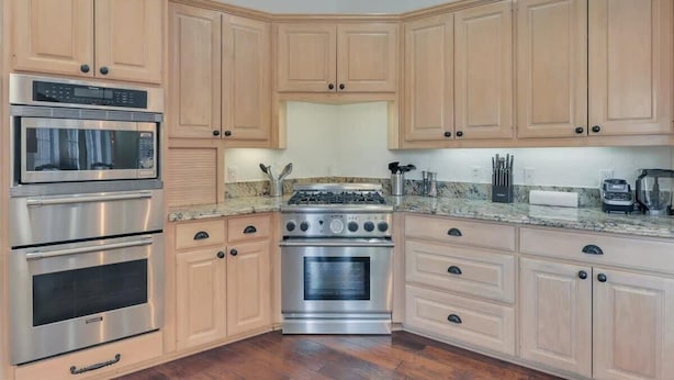 A kitchen with light wooden cabinets, stainless steel appliances, and a granite countertop. - Gorgeous Vacation Home w/ Private Pool (Mesquite)