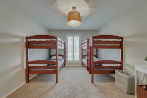 A room with bunk beds, a window, a ceiling light, and a trash bin. - Best of Richardson 5bd/3ba With Pool, Patio, BBQ (Richardson)