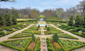 A formal garden with symmetrical pathways, a central water feature, and neatly trimmed hedges. - 5-bd/2-ba Vacation Retreat w/ Pool, Hot Tub & bbq (Fort Worth)