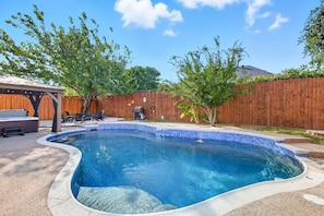 A backyard with a swimming pool, a wooden fence, and a patio area with outdoor furniture. - 5-bd/2-ba Vacation Retreat w/ Pool, Hot Tub & bbq (Fort Worth)