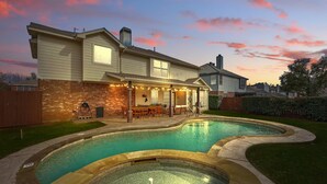 A house with a swimming pool, a covered patio, and a brick exterior. - 4-bd/2.5-ba Tropical Pool Oasis With a Game Room (Flower Mound)