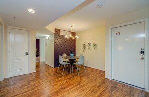 Um interior moderno com área de jantar, piso de madeira e porta de segurança.