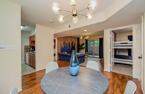 Ein modernes Interieur mit Essbereich, Küche und Wohnbereich inklusive Sofa und dekorativer Wand.