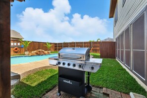 A backyard with a grill, a swimming pool, and a wooden fence. - 5bd/3ba Pool Oasis Come Rest, Relax & recharge (Burleson)