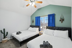 A bedroom with two beds, a ceiling fan, a window with blue curtains, and a cactus plant. - 5bd/3ba Pool Oasis Come Rest, Relax & recharge (Burleson)