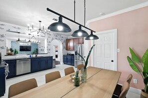 Una cocina moderna con armarios oscuros, una isla central e iluminación colgante.