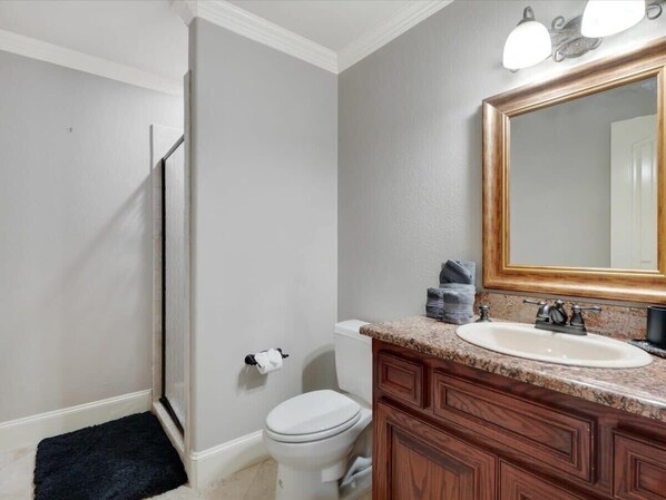 A bathroom with a toilet, sink, vanity, and a shower. - Luxury 4000sqft, Hot Tub, Games, Cinema, Ftworth, Attst (Kennedale)