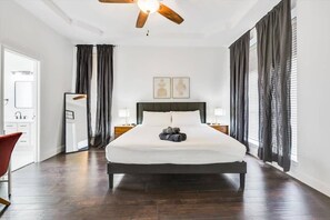 A hotel room with a large bed, a ceiling fan, and a view of the city through the windows. - Southern Living At Its Best-pool, BBQ (Waxahachie)