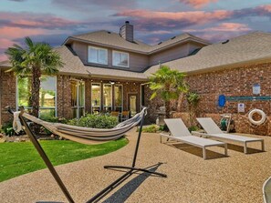 A house with a brick exterior, a front porch, and a hammock. - Southern Charm & Luxury Living - BBQ & Pool (Rockwall)