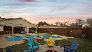 A backyard with a swimming pool, outdoor seating, and a fire pit. - Best of Desoto 4br,3ba With Pool, Hottub, Cinema (DeSoto)