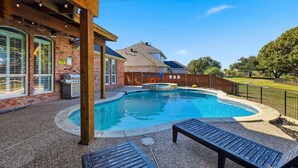 A backyard with a swimming pool, a barbecue area, and a wooden pergola. - 6BD Luxury Retreat w Backyard & Access Golf Course (Frisco)