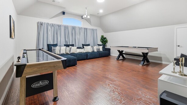 A spacious room with a pool table, a foosball table, and a sofa with cushions. - 6BD Luxury Retreat w Backyard & Access Golf Course (Frisco)