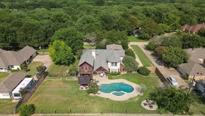A large house with a swimming pool surrounded by a fenced yard. - Rustic Cabin Mansion - Hot Tub, Gym, Cinema, Pool (McKinney)