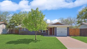 A residential house with a front yard, a garage, and a driveway. - 4-bd Luxury Retreat Pool, Grill, Outdoor cinema (Richardson)