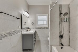 Une salle de bain moderne avec un meuble-lavabo, une douche et une fenêtre.
