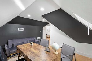 A modern room with a wooden table, grey sofas, a globe, and a staircase. - Best of Carrollton - Luxury, Pool, Hot Tub, Games (Carrollton)