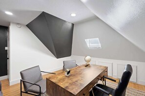 A conference room with a wooden table, two grey chairs, a globe, and a black chair. - Best of Carrollton - Luxury, Pool, Hot Tub, Games (Carrollton)