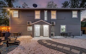 Ein zweistöckiges Haus mit Veranda, Grill und Satellitenschüssel.