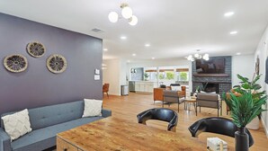 Ein modernes Wohnzimmer mit Sofa, Esstisch, Stühlen und Kamin.