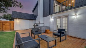 A patio with outdoor furniture, a grill, and a wooden deck. - Stunning Modern Dream Home, 5-bd, Sleeps 14 (Houston)