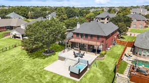 En bostadsfastighet med en stor trädgård, ett bubbelbad och en swimmingpool.
