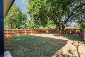 Ein Garten mit Holzfence, einem Baum und einer Rasenfläche.