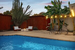 A backyard with a swimming pool, wooden fence, and outdoor seating. - Best of Allen at Fountain Park 5-bd/2-ba w/ Pool (Allen)