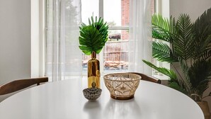 A dining table with a decorative bowl, a potted plant, and a vase with a green plant. - Live Like Royalty - Highland Village 6BR Mansion (Lewisville)