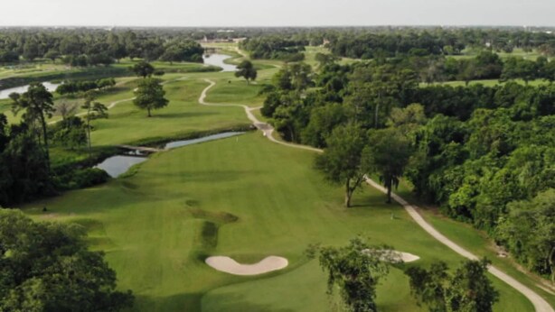 Ein Golfplatz mit einem Wasserhindernis, Sandbunkern und einem gewundenen Weg.