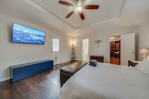 A bedroom with a bed, a TV, a ceiling fan, a bench, a desk, and a walk-in closet. - Central Plano 4-bd/2-ba Pool Retreat, Sleeps 10 (Plano)