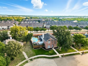 A residential area with multiple townhouses, a swimming pool, and a well-maintained lawn. - French-style 5-bd w/ Pool, Playground, Cinema (Lewisville)