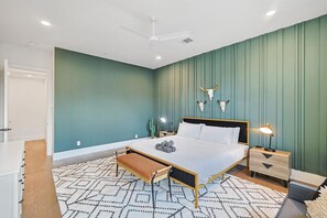 A bedroom with a bed, bedside tables, a ceiling fan, and a nightstand with a lamp. - Best of The Cedars - Dallas Views, Rooftop Luxury (Dallas)