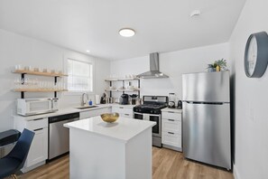 A modern kitchen with white cabinetry, stainless steel appliances, and a central island. - Charming Historic 3B Heart of Dallas - Sleeps 12 (Dallas)