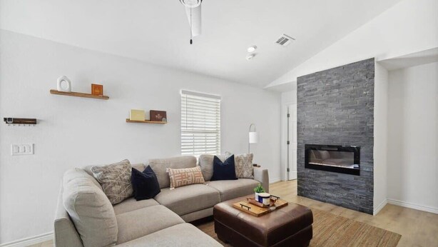A modern living room with a sectional sofa, a fireplace, and a minimalist design. - Cozy & Modern Home in Heart of Dallas (Dallas)