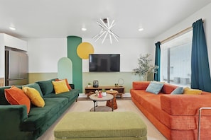 A modern living room with a sofa, a coffee table, and a TV. - Heart of Dallas in Knox Henderson Sleeps 4 (Dallas)