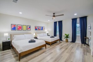 Ein Hotelzimmer mit zwei Betten, einem Deckenventilator und Bildern an der Wand.