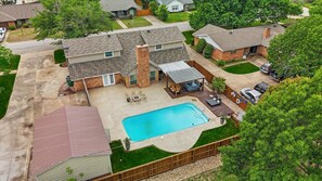 A residential property with a backyard pool, a covered patio, and a fenced yard. - 5BR Near At&t Stadium Pool, Golf Sim, EV (North Richland Hills)