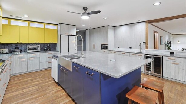 A modern kitchen with a large island, built-in appliances, and a ceiling fan. - Russwood Acres Estate ft Gym, Cinema, Pool Table (McKinney)