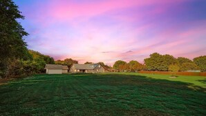 A large grassy field with a barn and a house in the background. - Russwood Acres Estate ft Gym, Cinema, Pool Table (McKinney)