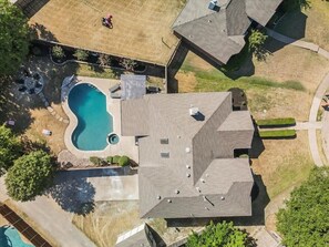 An aerial view of a residential area with a swimming pool, a covered patio, and a house with a sloped roof. - Modern Rustic Oasis/games/cinema/utd/plano/frisco (Allen)