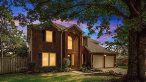 A two-story brick house with a garage, a front yard, and a large tree. - Tropical Pool Oasis - 5 BR, Foosbal, Cinema (Flower Mound)