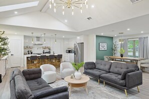 Ein modernes Wohnzimmer mit einer Couch, Sesseln und einem Couchtisch.