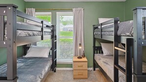 A room with bunk beds, a window with curtains, and a bedside table with a lamp. - 3-bd Backyard Oasis w Pool, Patio, Firepit (Irving)