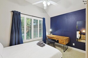 A bedroom with a bed, a desk, a chair, a ceiling fan, and a window with curtains. - 5bd, 2BA w Backyard Oasis, Pool, Jacuzzi, Firepit (Denton)