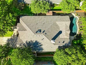 An aerial view of a residential property with a swimming pool, a covered patio area, and a lawn. - 5bd, 2BA w Backyard Oasis, Pool, Jacuzzi, Firepit (Denton)