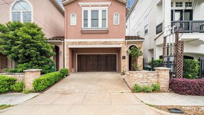 A two-story house with a garage, stone foundation, and a well-maintained front yard. - Houston Centrally Located w/ Backyard Pool Retreat (Houston)